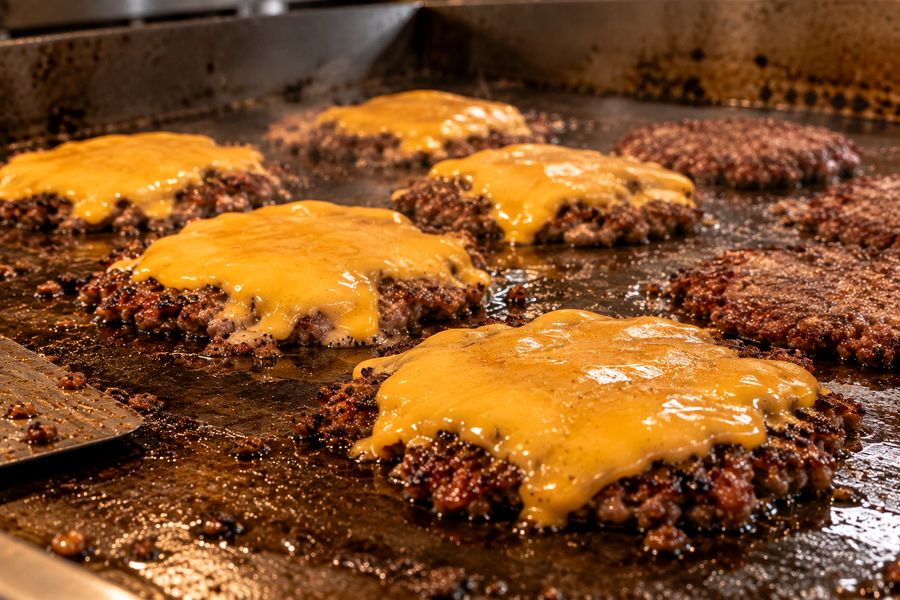 Cheddar derritiéndose sobre la carne en la plancha